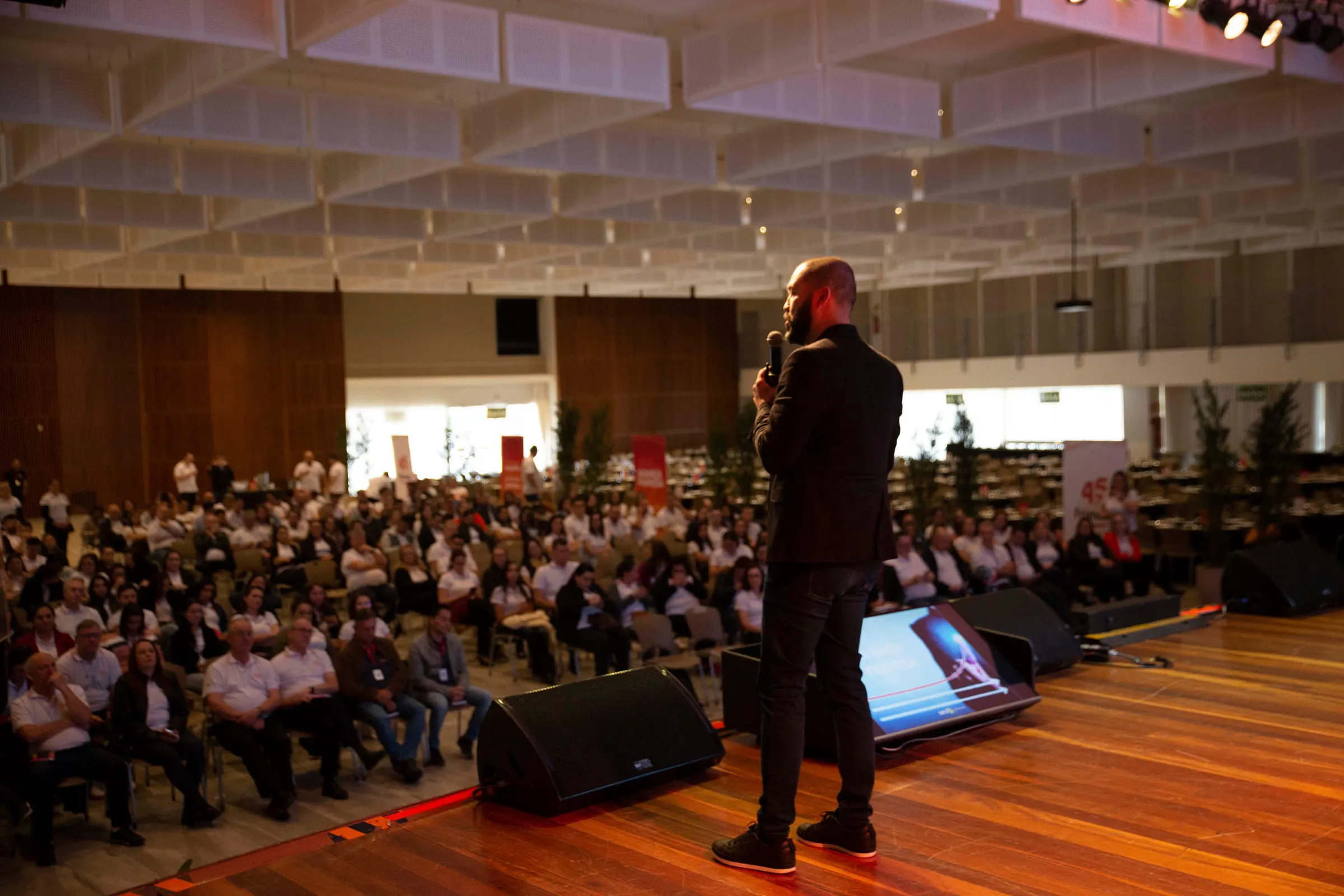 Palestrante da BTX Business School no palco, diante de uma plateia de executivos em auditório